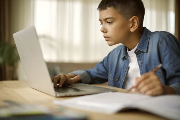 Teenage boy using laptop for homework